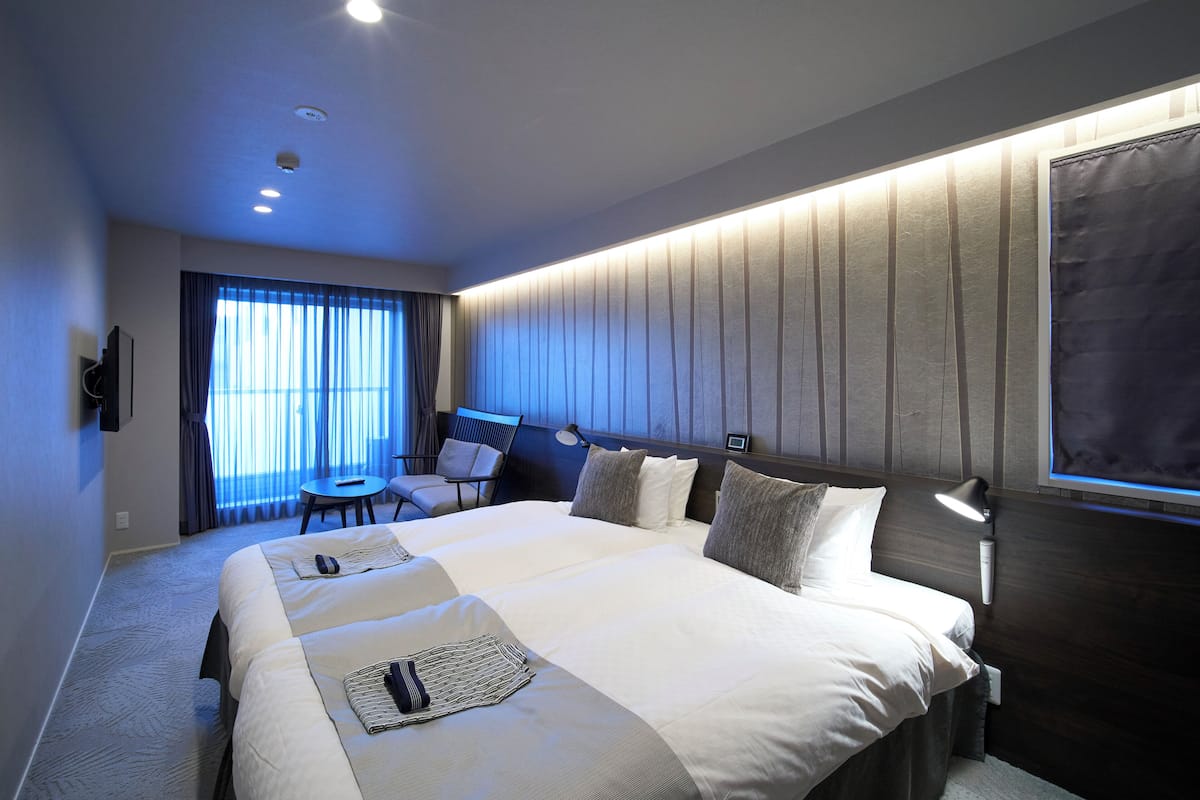 Une chambre d’hôtel moderne avec un grand lit, un bureau et une chaise.