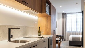 Una cocina moderna con un lavaplatos integrado, armarios de madera y un comedor con mesa y sillas.