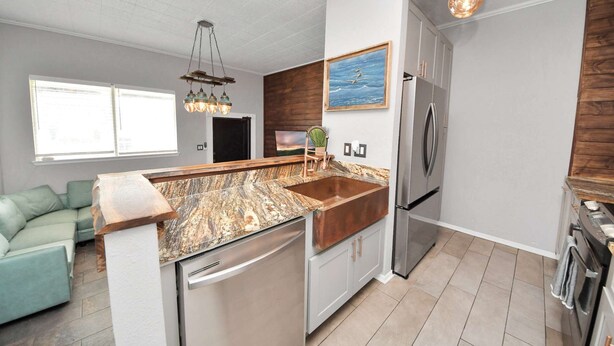 Una cocina moderna con una isla central, electrodomésticos de acero inoxidable y una pared de acento de madera.