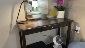 A wooden desk with a mirror, a lamp, a small potted plant, and a fan. - Redman Rental Guesthouse (Tucson)