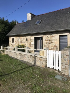 Charming single-story home with a pitched roof, stone and brick exterior, and a cozy porch.