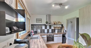 A compact kitchen with a microwave, stove, sink, and a refrigerator.