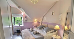 A bedroom with a large bed, two bedside tables, a window with a view, and a ceiling light. - Sessile oaks - PLESLIN TRIGAVOU (PLESLIN TRIGAVOU)