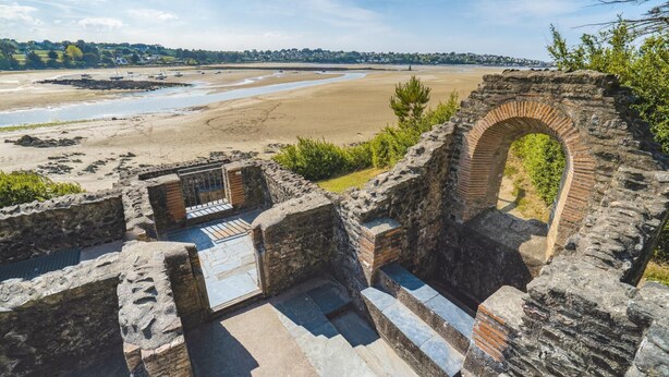 Una estructura de pedra antiga amb un arc de rajola i escales que baixen a un nivell inferior.
