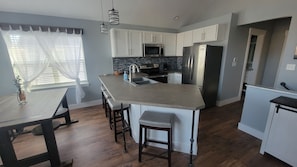 Enjoy cooking in this well-lit kitchen with a central island and stainless steel appliances.