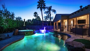 A swimming pool with a fountain, surrounded by palm trees and a house with a patio. - Casa Serenity Luxury Living w/ Pool & Jacuzzi (Indio)
