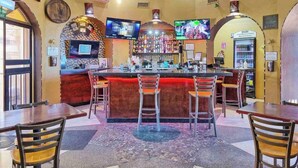 A bar area with a counter, multiple TVs, and a seating area with chairs and tables. - Vibe by the Sea of Cortez @Princesa Resort (Puerto Peñasco, Son)