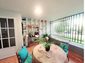 Enjoy a meal for two at the round dining table, with a view of the outdoors through the large window.