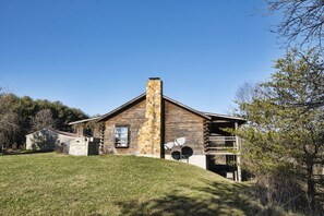 Eine Blockhütte mit Steinofen, Satellitenschüsseln und einer kleinen Veranda.