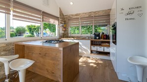 A modern kitchen with a central island, wooden countertops, and a view of greenery outside. - Beautiful home in Zaton Obrovacki (Zaton Obrovacki)