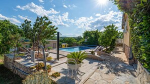 A stone patio with a swimming pool, surrounded by greenery and a stone wall. - Beautiful home in Zaton Obrovacki (Zaton Obrovacki)