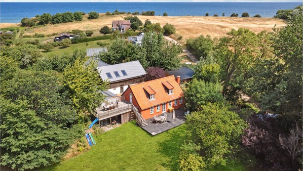 Ein Haus mit Terrasse, kleinem Pool und Meerblick.