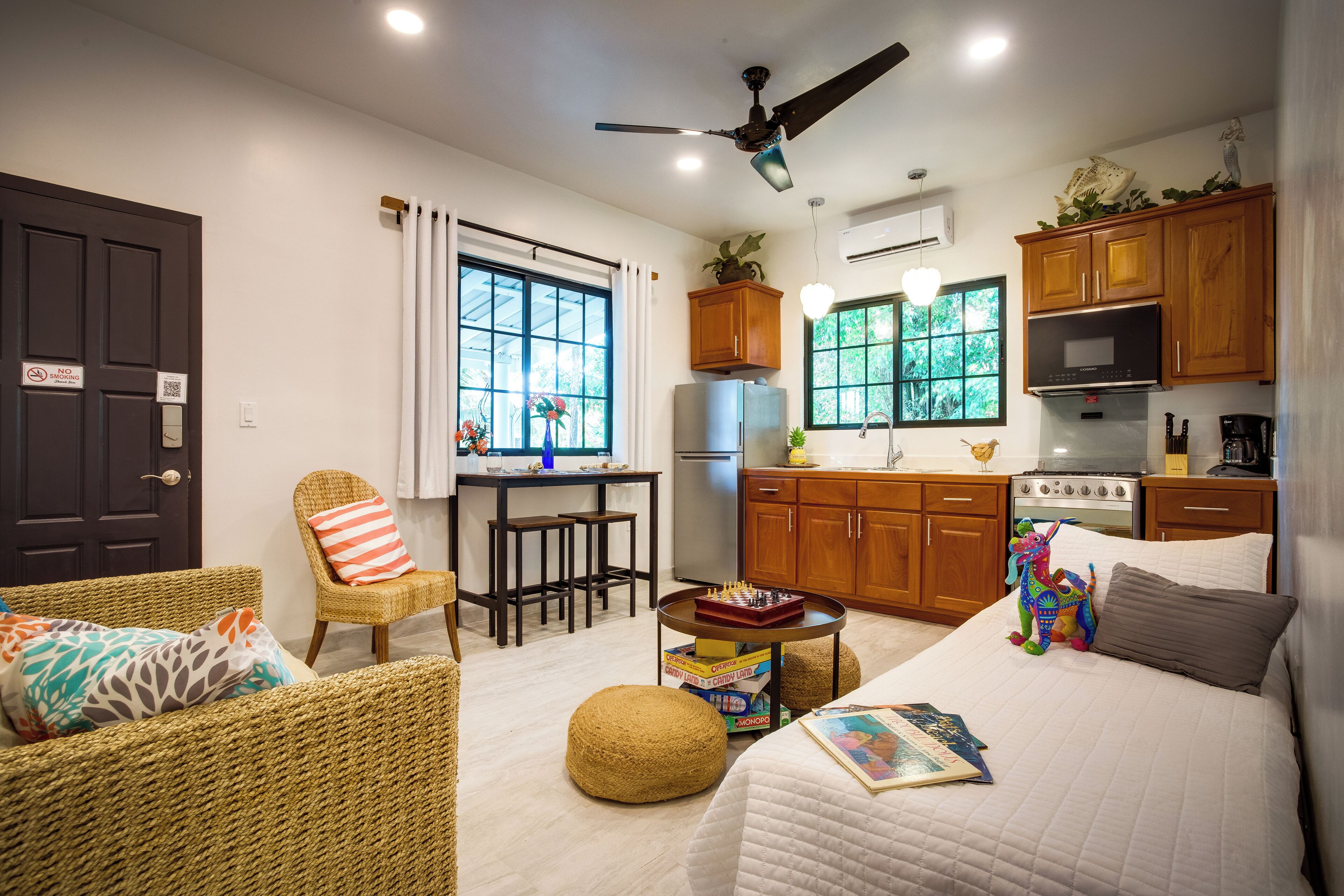 Un espacio habitable compacto con kitchenette, comedor y dormitorio.