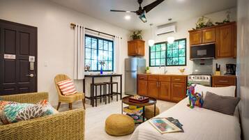 Un espacio habitable compacto con kitchenette, comedor y dormitorio.