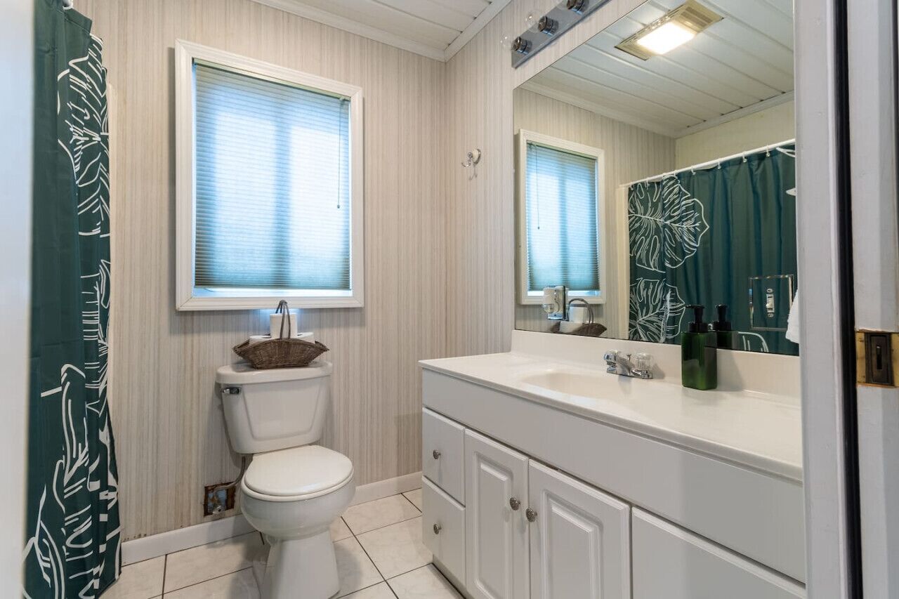 Une salle de bain avec des toilettes, un lavabo et un miroir.