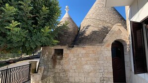 Un edificio de piedra con tres techos cónicos y un árbol en primer plano.