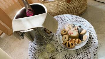 A table with a bottle of champagne, a basket, and a plate of pastries.