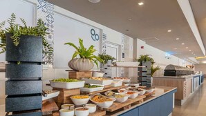 Montaje de bufé con diversos alimentos y plantas.