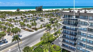 Ein Hotel mit Parkplatz, Palmen und Blick auf den Strand.