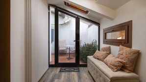 A room with a sliding glass door leading to an outdoor patio, a sofa with patterned cushions, and a framed picture on the wall. - Appartamento a 200 metri dall\'Arena con 3 camere da letto e terrazzo (Verona)