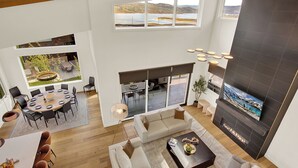 Amplia sala de estar con chimenea, una mesa de comedor y un gran ventanal con vistas a un paisaje pintoresco.
