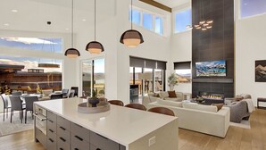 Amplia sala de estar con una isla grande, muebles modernos y una chimenea.