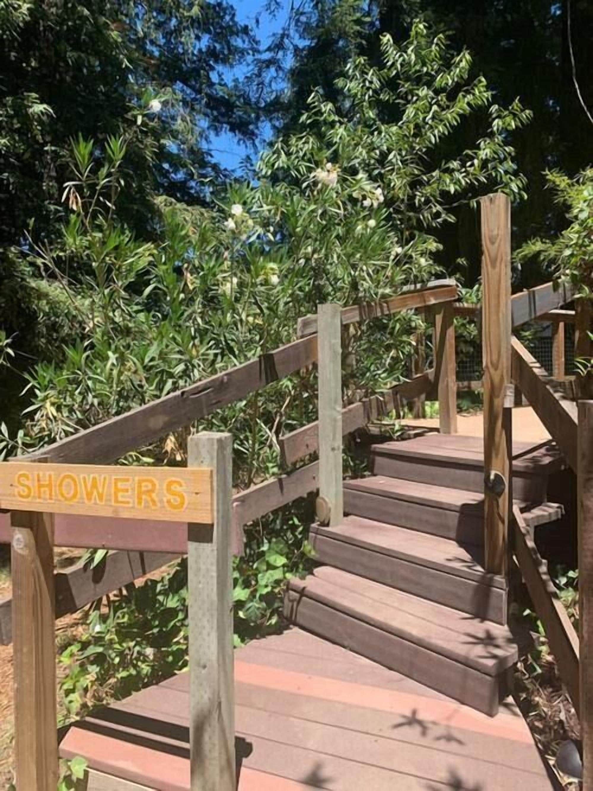 A wooden staircase with a sign reading "SHOWERS" leading to a covered area.