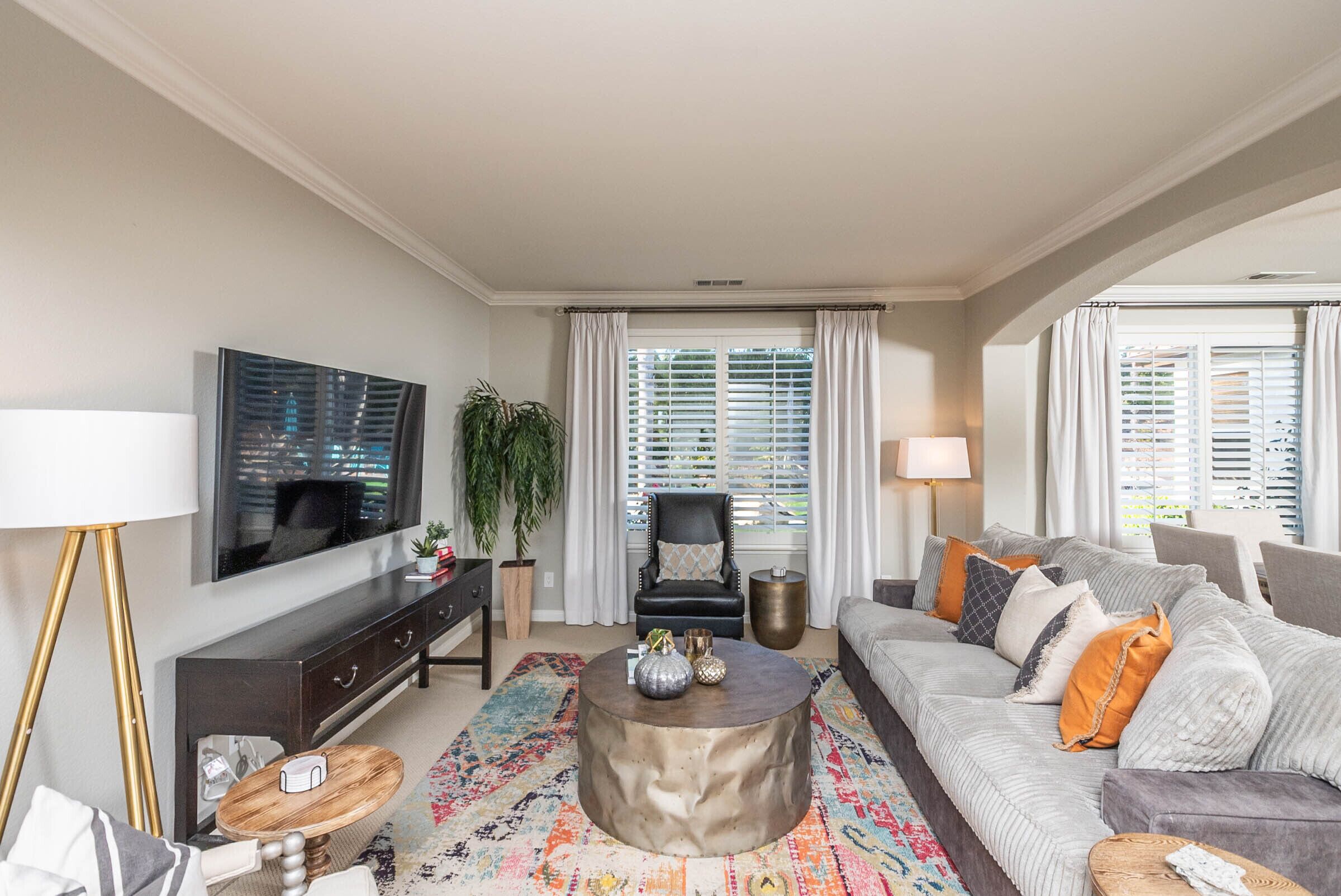 A living room with a television, sofa, coffee table, and decorative items.