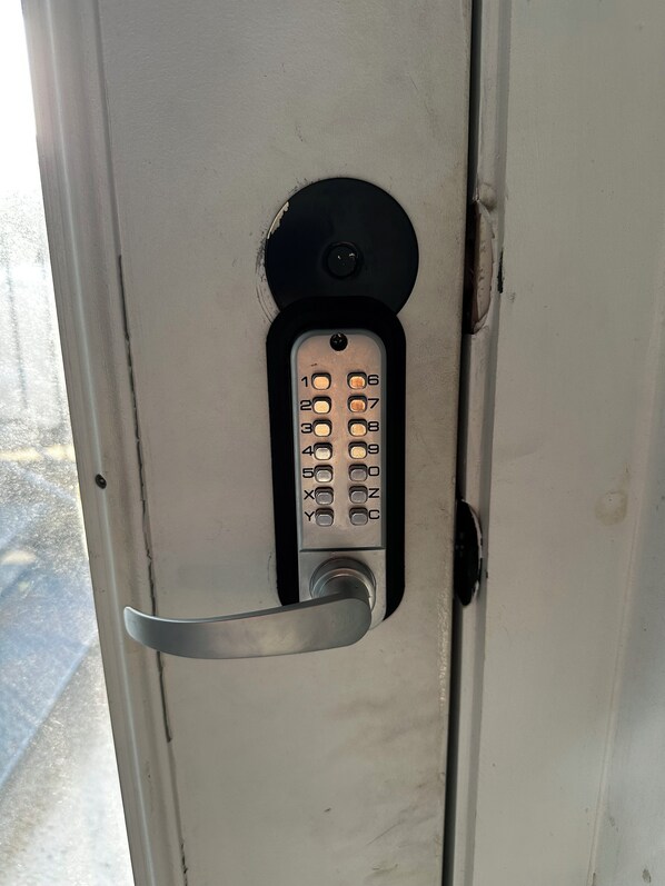 Een deur met een cijferslot en een metalen handgreep.