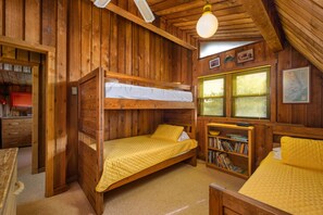 Eine Holzhütte mit Etagenbetten, einem Bücherregal und einer Karte an der Wand.