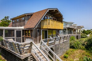 A wooden house with a balcony and a deck.