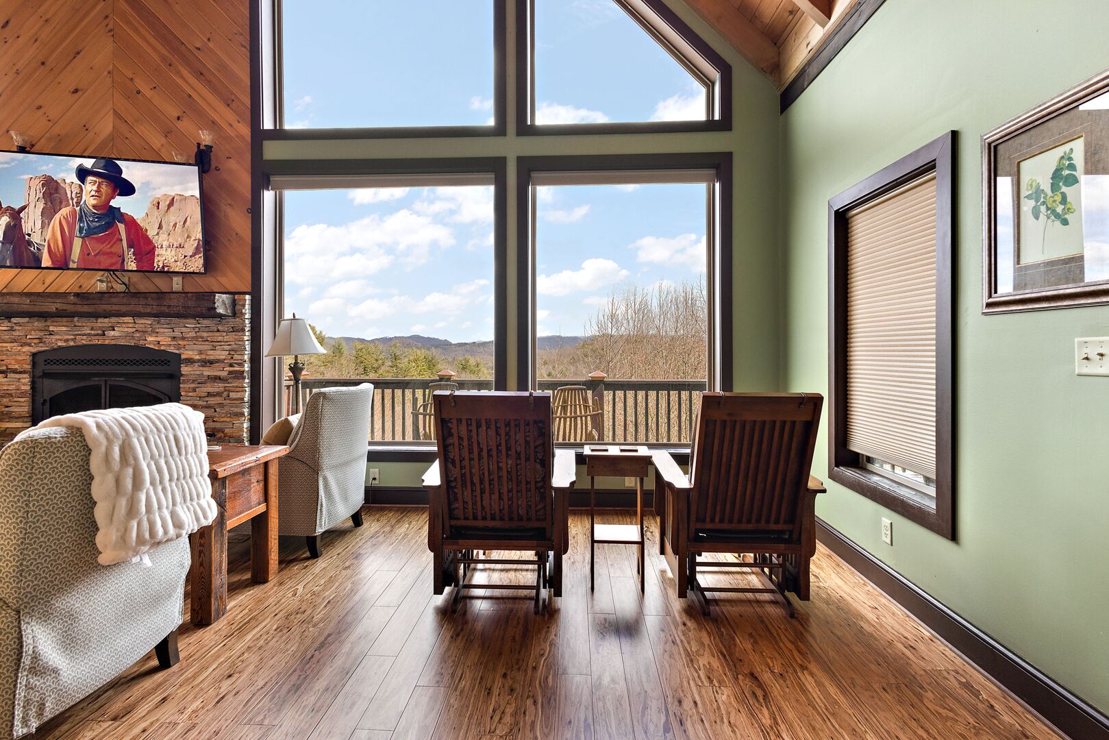 Una habitación acogedora con chimenea, ventanas amplias y vistas a las montañas.