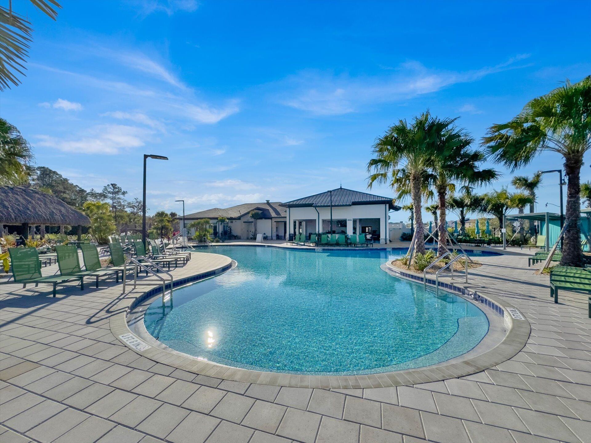 A swimming pool with lounge chairs and a building in the background.
