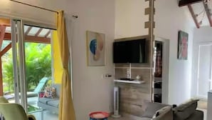 Een moderne woonkamer met een bank, een televisie en een bijzettafeltje.