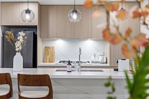 Enjoy cooking in this well-equipped kitchen with a central island, sink, and sleek cabinetry.