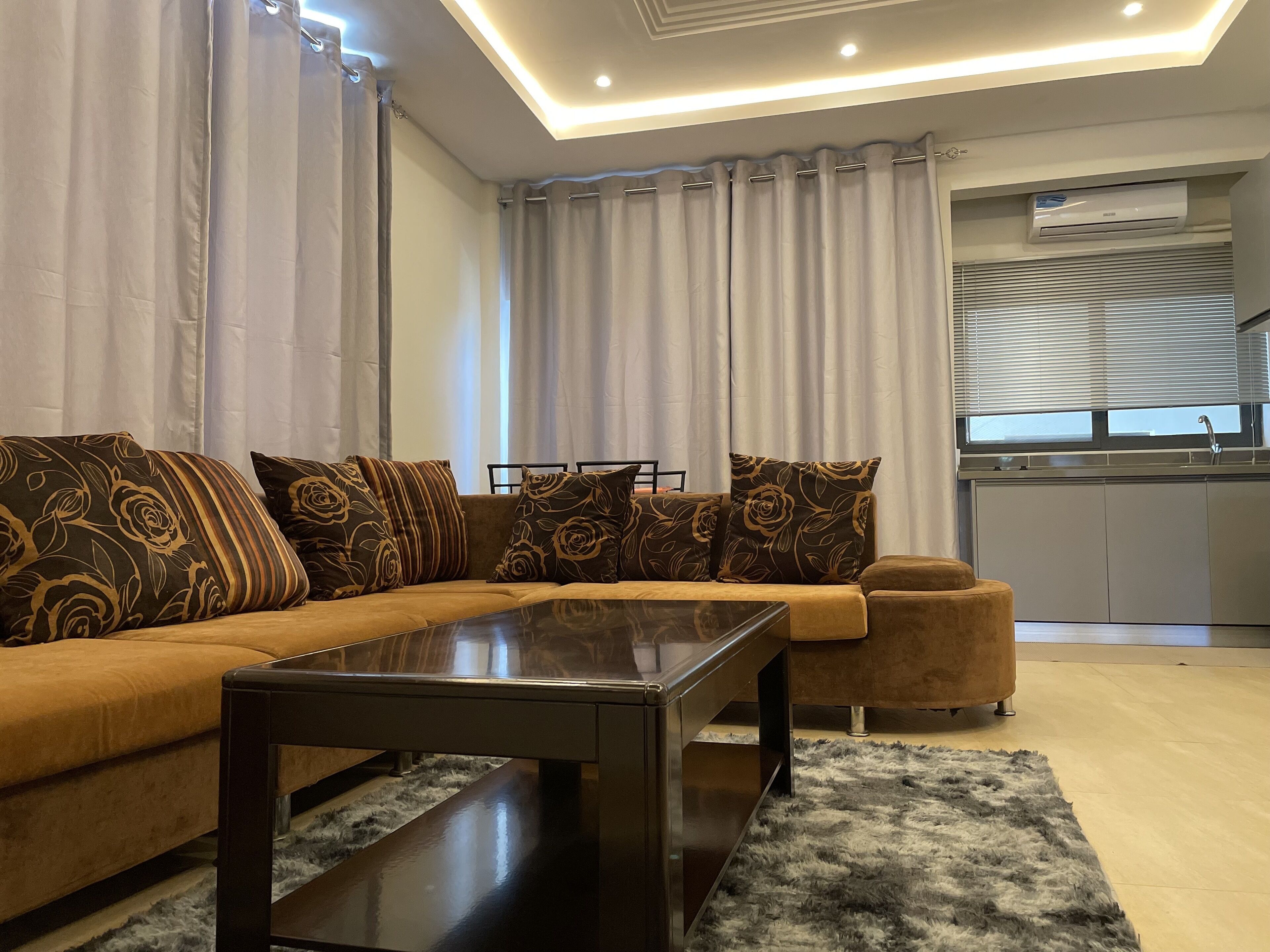 A modern living room with a sofa, a coffee table, and a rug.