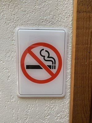 A no-smoking sign mounted on a textured wall.