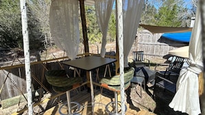 A covered outdoor patio with a table and chairs, a ceiling fan, and a view of the surrounding area. - Good Location / Good people AND GOOD VIBES ONLY  (Spring Hill)