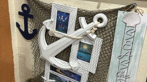 A nautical-themed decor with an anchor, framed pictures, and a welcome sign. - Good Location / Good people AND GOOD VIBES ONLY  (Spring Hill)