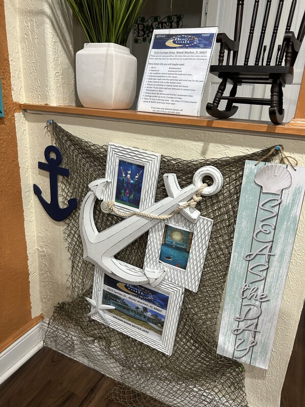 A nautical-themed decor with an anchor, framed pictures, and a welcome sign. - Good Location / Good people AND GOOD VIBES ONLY  (Spring Hill)