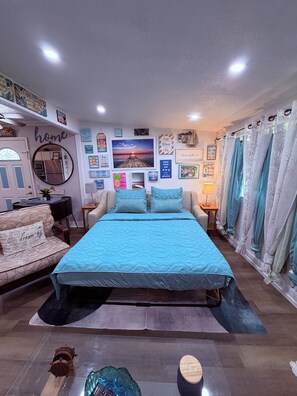 A bedroom with a bed, a sofa, a mirror, and various wall decorations. - Good Location / Good people AND GOOD VIBES ONLY  (Spring Hill)