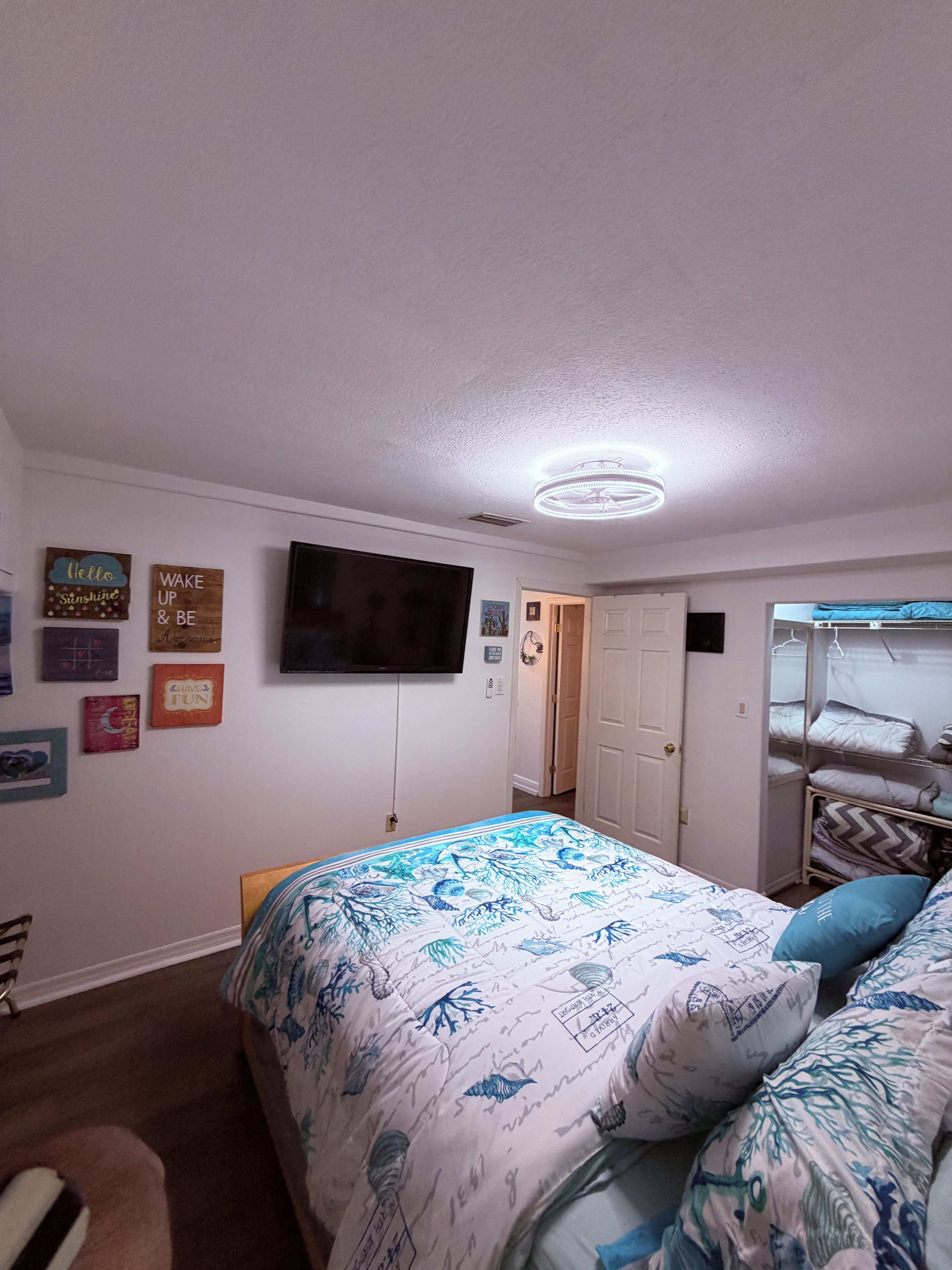 A bedroom with a bed, a television, and wall decorations.