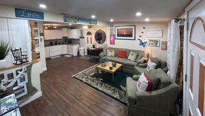 A cozy living room with a sofa, coffee table, and a dining area with a table and chairs. - Good Location / Good people AND GOOD VIBES ONLY  (Spring Hill)