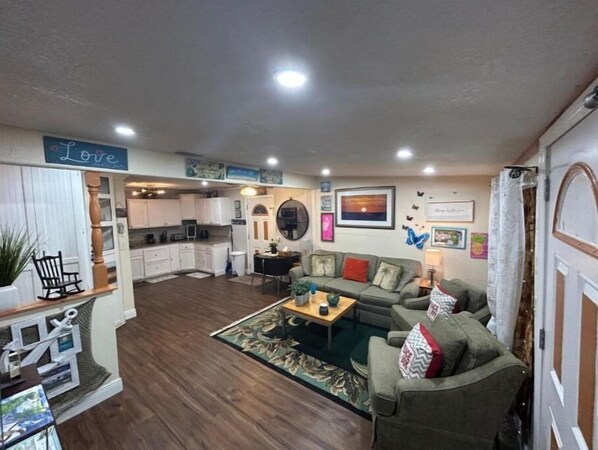 A cozy living room with a sofa, coffee table, and a dining area with a table and chairs.