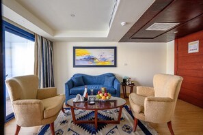 Habitación Deluxe con 1 cama matrimonial o 2 individuales | Área de sala de estar | Televisión de pantalla plana, chimenea y monitor de computadora 