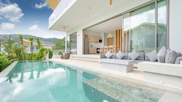 A modern house with a swimming pool, outdoor seating, and a kitchen visible through the glass doors. - Himmapana Villas - Hills  (Kamala)