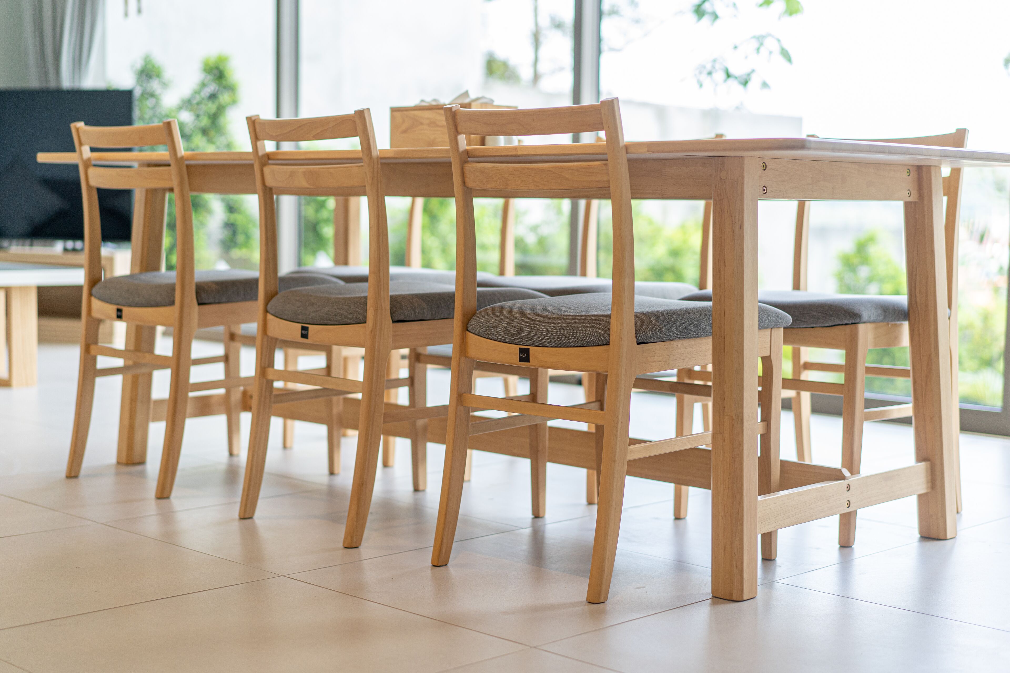 A wooden dining table with four chairs, each with a cushion.