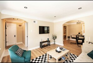 Relax in this stylish living room with a curved door, checkered rug, and comfortable armchair.