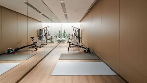 Ein modernes Fitnessstudio mit Trainingsgeräten, Yogamatten und einem minimalistischen Design.