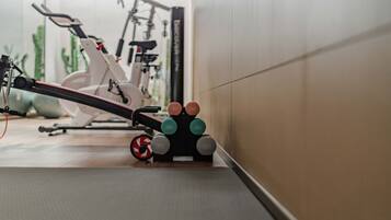 A gym with exercise equipment, including a stationary bike and weight plates.